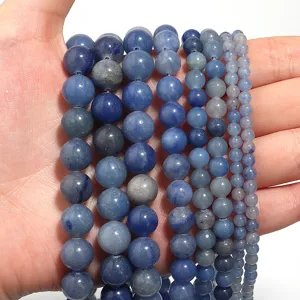 Close-up detail of multi-size natural blue aventurine gemstone round beads in strands.