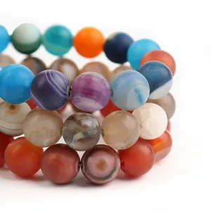 Primo piano di perline rotonde in agata naturale satinata multicolore, accessori fai da te.