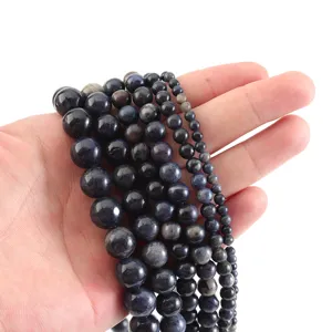Vista detallada de hilos de cuentas de piedras preciosas azul oscuro de varios tamaños para accesorios.