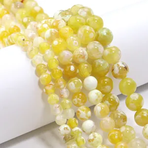 Primo piano dettagliato di perline in agata bicolore gialla per accessori di gioielli fai da te.