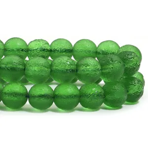 Gros plan de perles en verre mat vert, perles texturées pour la fabrication de bijoux DIY.