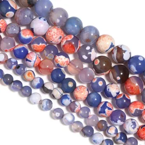Primo piano dettagliato di perle di agata bicolore fiamma naturale per gioielli fai-da-te.