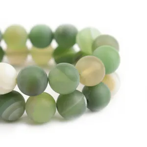 Primo piano dettagliato di perle rotonde in agata verde smerigliata per gioielli fai da te