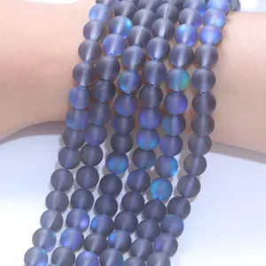 Detailansicht von matten Aurora Kristallperlen Strängen mit feiner Textur und blauem Schimmer.