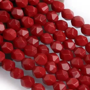 Dettaglio in primo piano di perline di agata di cristallo sfaccettate rosso vivo per gioielli.