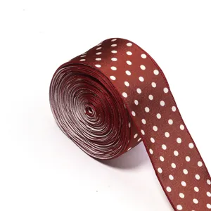 Detail view of burgundy polka dot satin ribbon roll, ideal for DIY crafts and hair accessories.