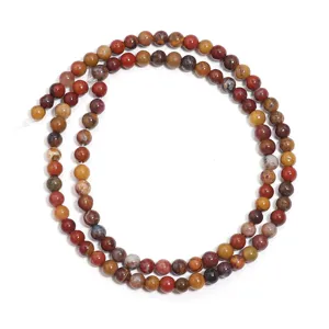 Primo piano di perline sfuse tonde in agata naturale multicolore per accessori di gioielli fai-da-te.