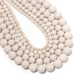 Close-up detail view of natural white fossil round beads with graduated sizes for DIY craft.