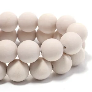 Detailed macro shot of natural white fossil stone matte round beads for DIY jewelry making.