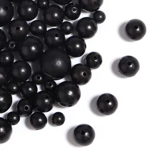 Gedetailleerde close-up van kleine zwarte ronde houten kralen voor DIY-sieraden en armbanden.