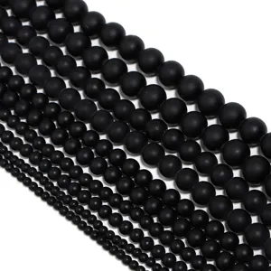 Detailweergave van matte zwarte agaat kralen in verschillende maten voor sieraden maken.