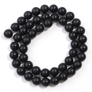 Korte close-up van matte zwarte agaat kralen, gladde gestructureerde kralen voor DIY sieraden.