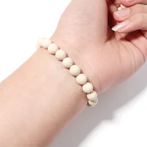 Close-up detail of a minimalist white beaded bracelet worn on wrist, elegant and delicate accessory.