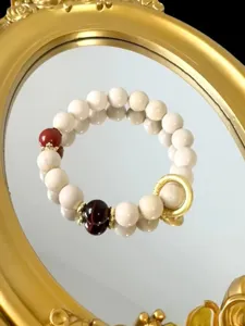 Exquisite natural white fossil beaded bracelet detail with gold ring and red stone accents chic.
