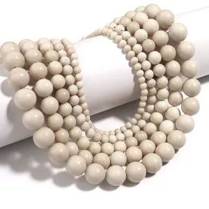 Close-up detail shot of natural white fossil round beads, perfect for DIY jewelry crafting accessories.