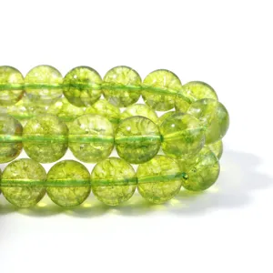 Close-up detail of green cracked crystal beads, translucent round DIY gemstone loose beads.