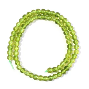 Green crystal loose beads detail close-up, round bead strand for DIY handmade jewelry crafting.