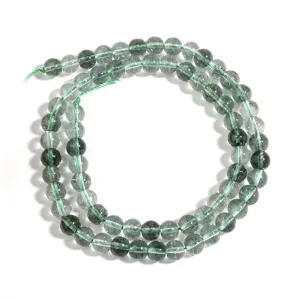 Green crystal loose bead detail, round gemstone strand for DIY jewelry making and bracelet design.