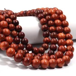 Detailansicht polierter roter Holzperlen, ideal für DIY-Schmuck und buddhistische Armbänder.