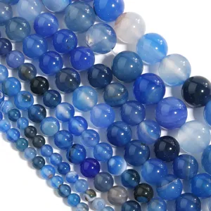 Close-up detail of smooth blue agate round beads, ideal for DIY handmade jewelry crafting.