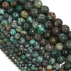 Primer plano de cuentas redondas de turquesa africana natural, textura detallada para joyería.