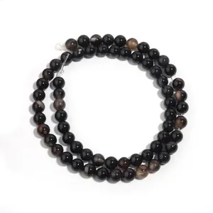 Natural black agate gemstone round beads detail for DIY jewelry making and bracelet strands.