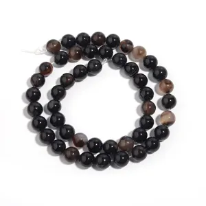 Detailed close-up view of natural black agate round gemstone beads strand for DIY jewelry making.