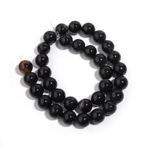 Natural black agate gemstone bead strand detail, smooth round loose beads for DIY jewelry.