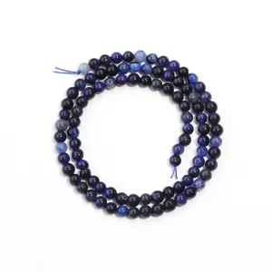 Gros plan de perles en pierres précieuses bleues en cercle, idéal pour la création de bijoux.