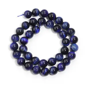Gros plan de perles de pierre précieuse œil de tigre bleu, perles rondes polies pour bijoux DIY.