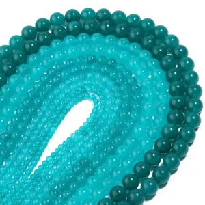 Nahaufnahme glatter runder Edelsteinperlen in den Farbverläufen Grün und Blau, DIY-Schmuck.