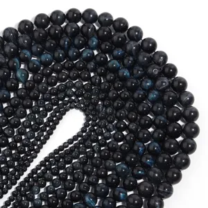 Detailed close-up view of dark blue tiger eye round beads arranged for DIY jewelry making.