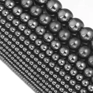 Close-up detail of smooth metallic black hematite round loose beads in multiple sizes.