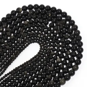 Detailed close-up view of natural golden obsidian loose round beads arranged in size gradient.