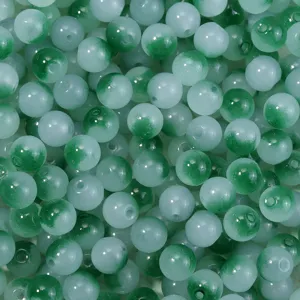 Nahaufnahme von grün-weißen Farbverlauf-Glasperlen für DIY-Schmuck und Bastelarbeiten.