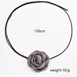 Collier long de fleur en tissu gris avec cordon noir, accessoire élégant camelia pour femme.