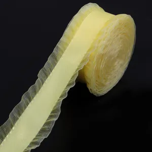 Vista dettagliata di un rotolo di nastro in organza arricciato giallo chiaro, tessuto.