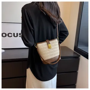 Borsa a secchiello vintage in paglia intrecciata con finiture in pelle marrone su modella