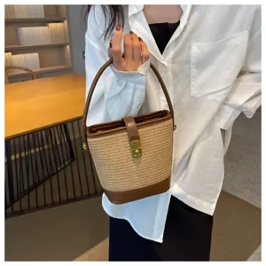Dettaglio di una borsa a secchiello retrò in paglia intrecciata con finiture in pelle