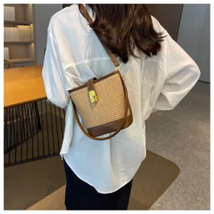 Vista posteriore di una modella che indossa una borsa a secchiello in paglia vintage