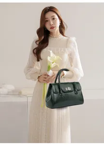 Vue détaillée de l'élégant sac à bandoulière vintage vert foncé avec poignée tressée.