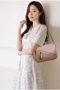 Detail view of women's soft litchi pattern leather shoulder crossbody bag in classic brown.