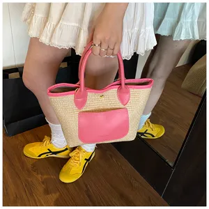 Detailed shot of straw handbag with pink leather trim and front pocket, perfect for casual summer.