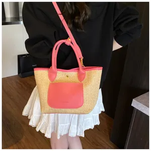 Detail view of stylish straw bucket bag with pink leather trim, perfect for casual commute.