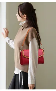 Close-up detail view showing the exquisite red leather shoulder bag with stylish contrast trim.