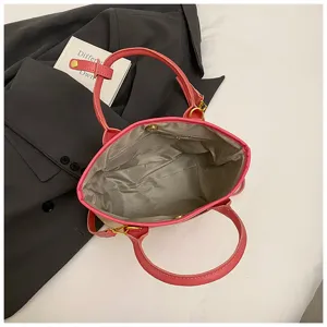 Detail view of pink straw bucket bag interior and handles on grey blazer background.