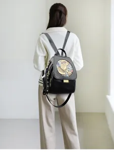 Women black leather embossed backpack detail view showing stylish strap and artistic flap design.