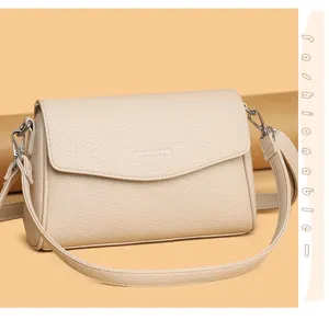 Primo piano della borsa a tracolla in pelle beige, con tessitura fine e dettagli metallici.