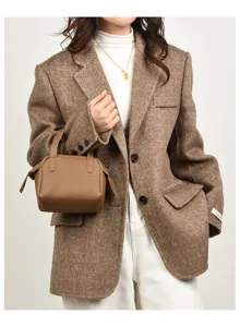 Dettaglio borsa pelle morbida litchi marrone, mini borsa a mano elegante da giorno.