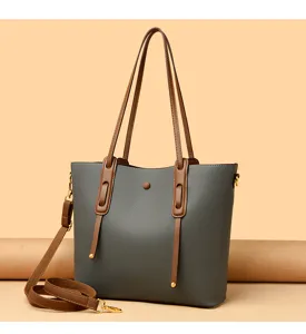 Detailed view of the stylish grey women's tote bag featuring brown leather handles and strap.
